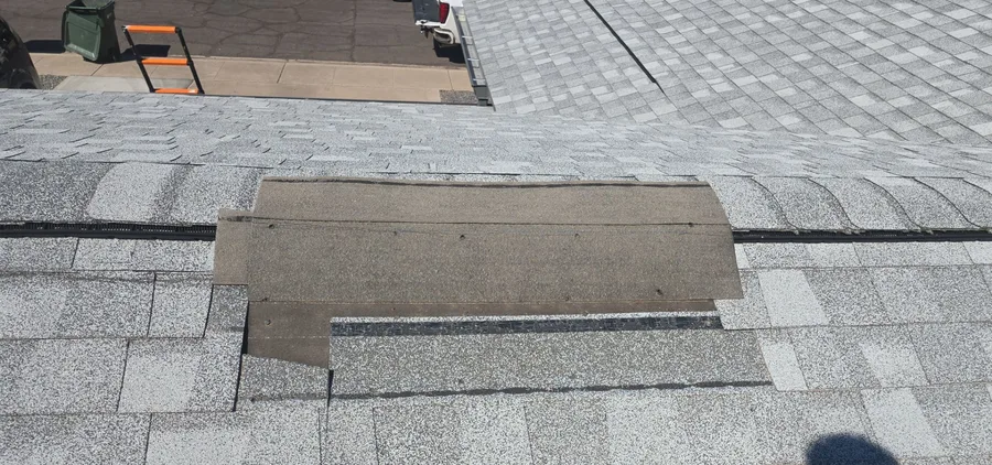 Shingle roof repair with a patched section